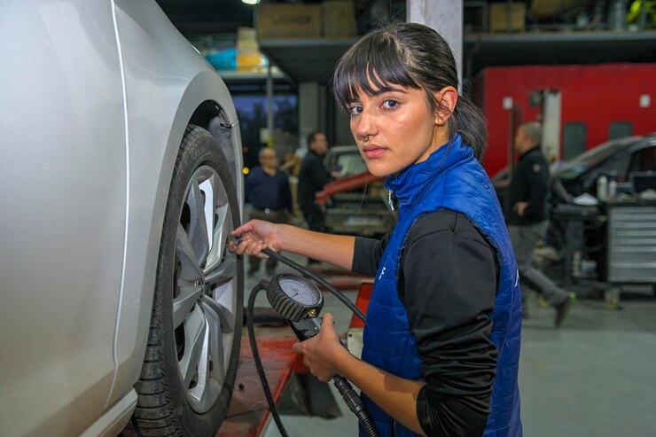 young-female-mechanic-checking-air-pressure-car-s-tyres