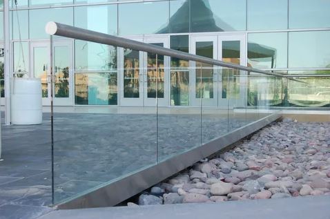 A modern spiral staircase featuring sleek glass railings, elegantly designed for contemporary home interiors.