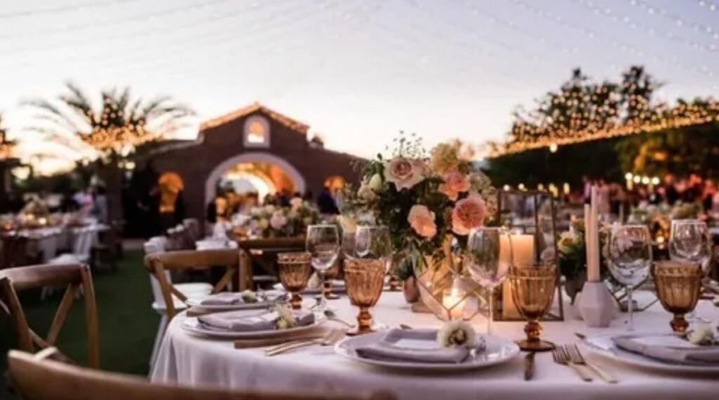 A romantic wedding reception at sunset, adorned with glowing candles and twinkling lights, creating a magical atmosphere.