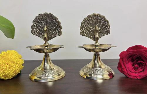 air of handcrafted brass peacock diyas with intricate traditional detailing for home puja
